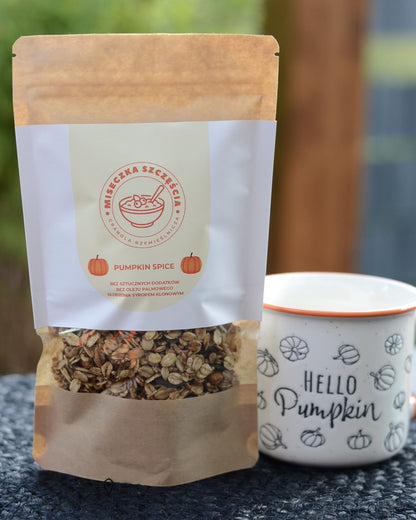 Torebka granoli Pumpkin Spice obok kubka z dyniami